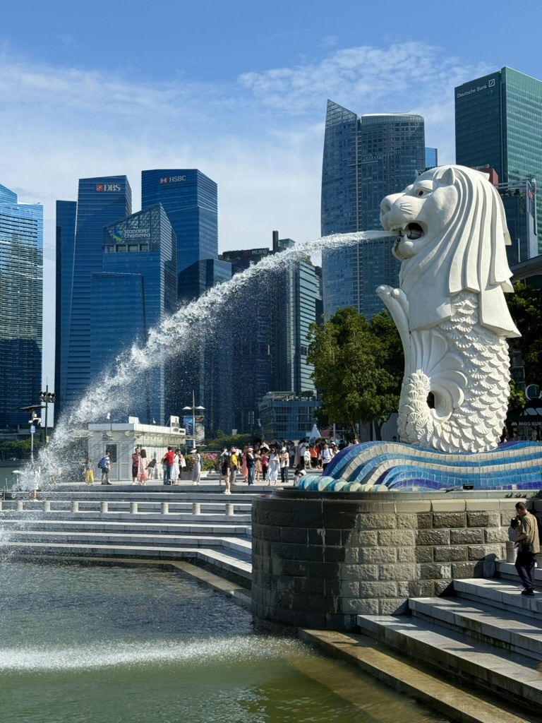 Merlion statue spraying water toward Marina Bay